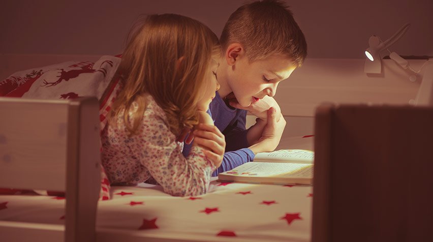 Kids reading stories in the top bunk