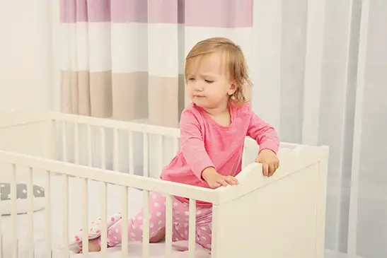 Standing toddler in crib