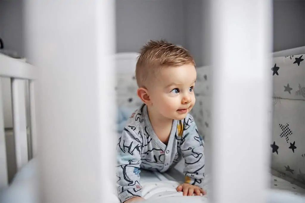 Baby crawling in crib