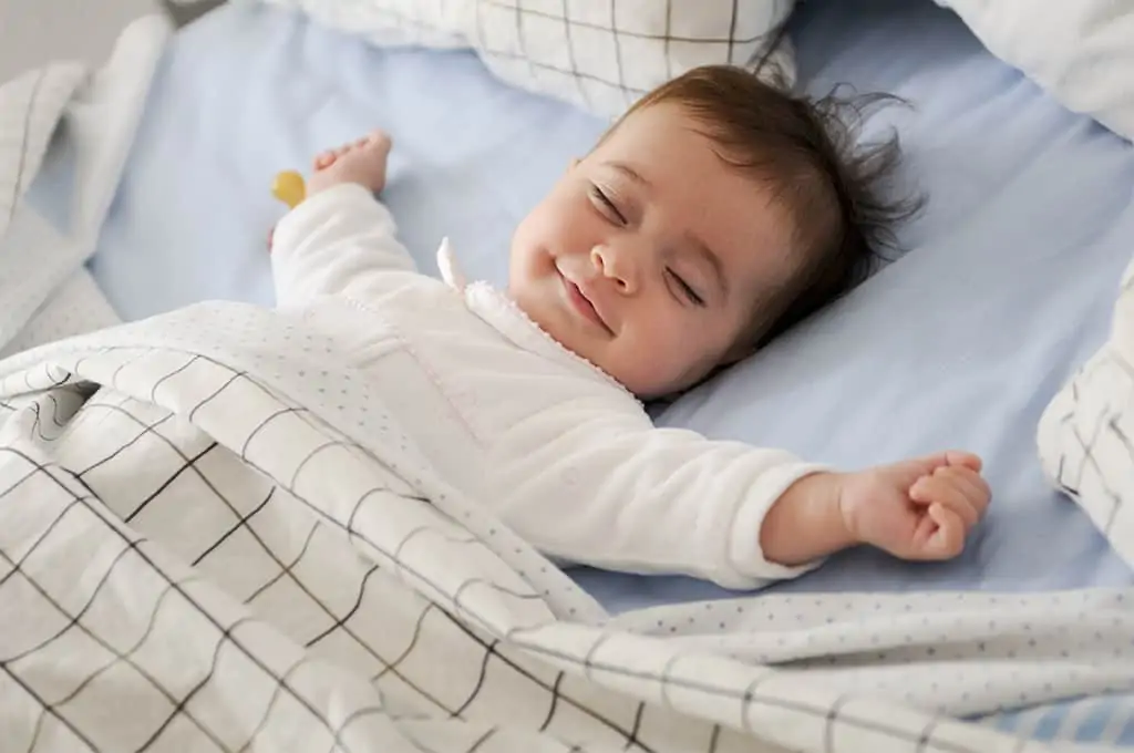 Happy baby sleeping with blanket